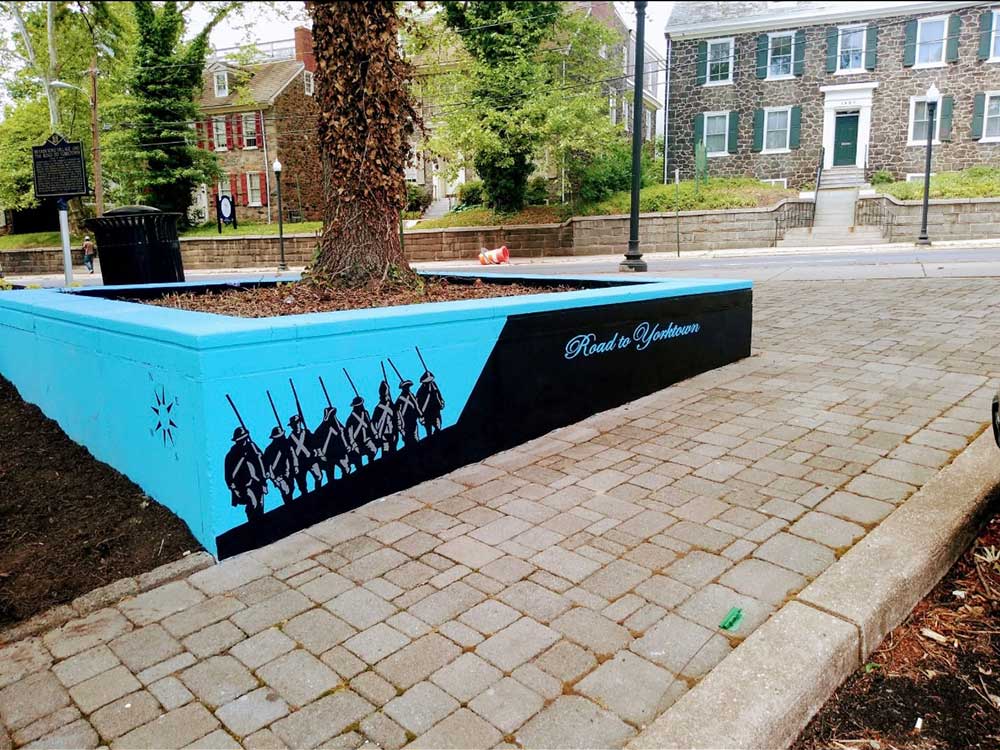 Mural depicting soldiers in Wilmington, DE, set against the backdrop of a nearby building.